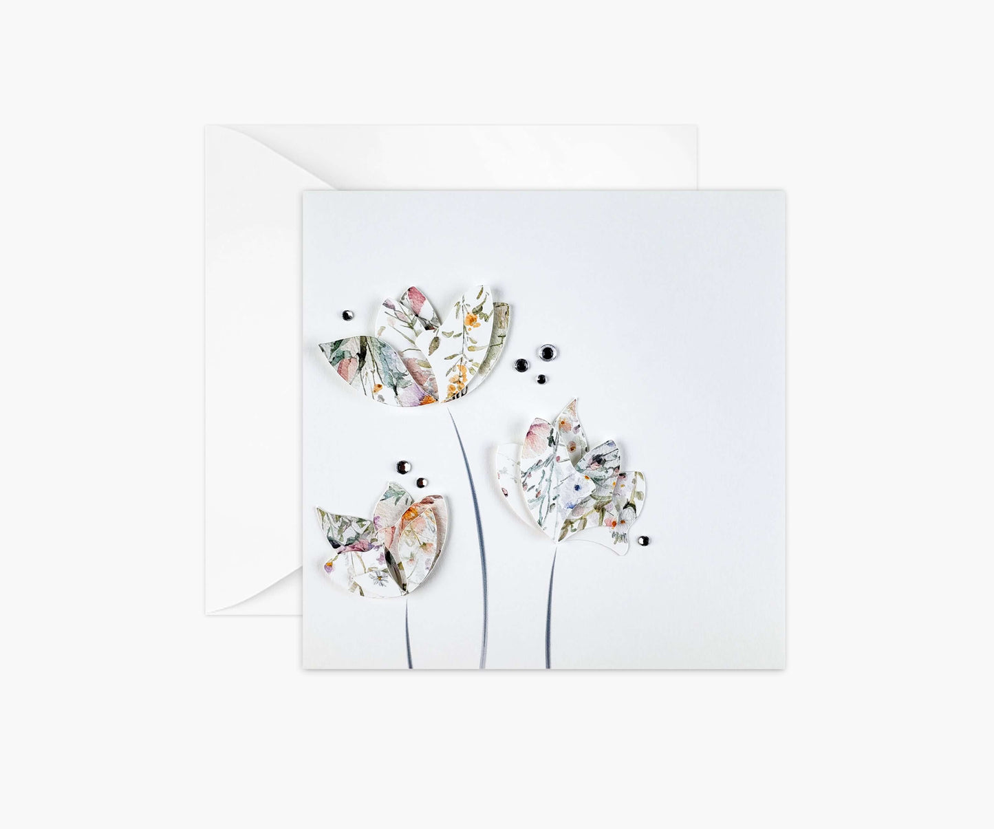 3 flowers die cut from floral patterned paper and layered. Silver gemstones highlighting