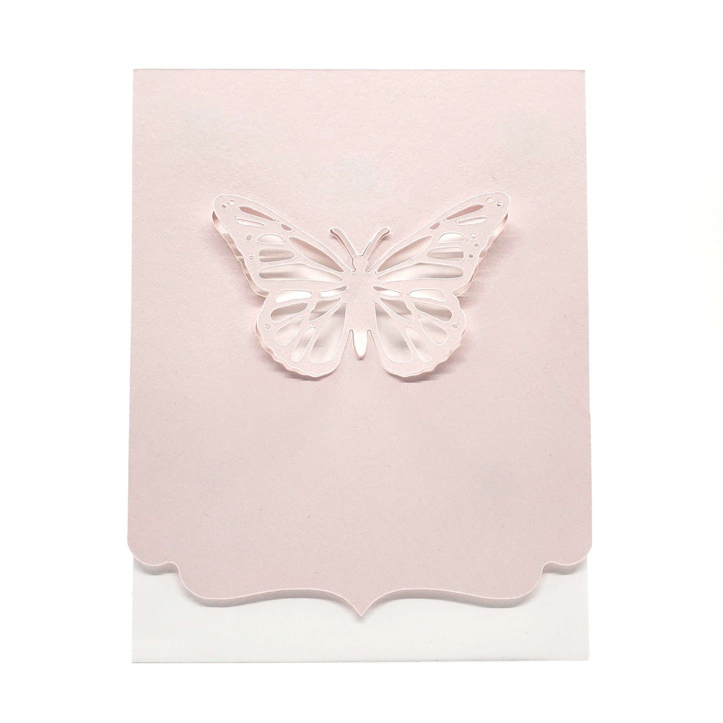 Die cut butterfly from pink cardstock with a decorative edge on a white card.