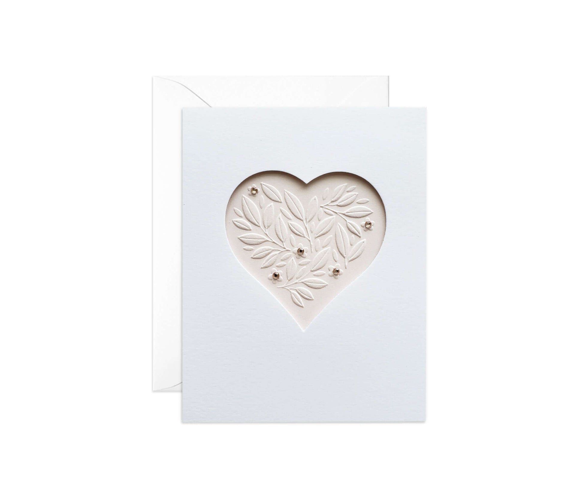 Die cut heart with embossed leaves on a pale pink paper with pink gemstones