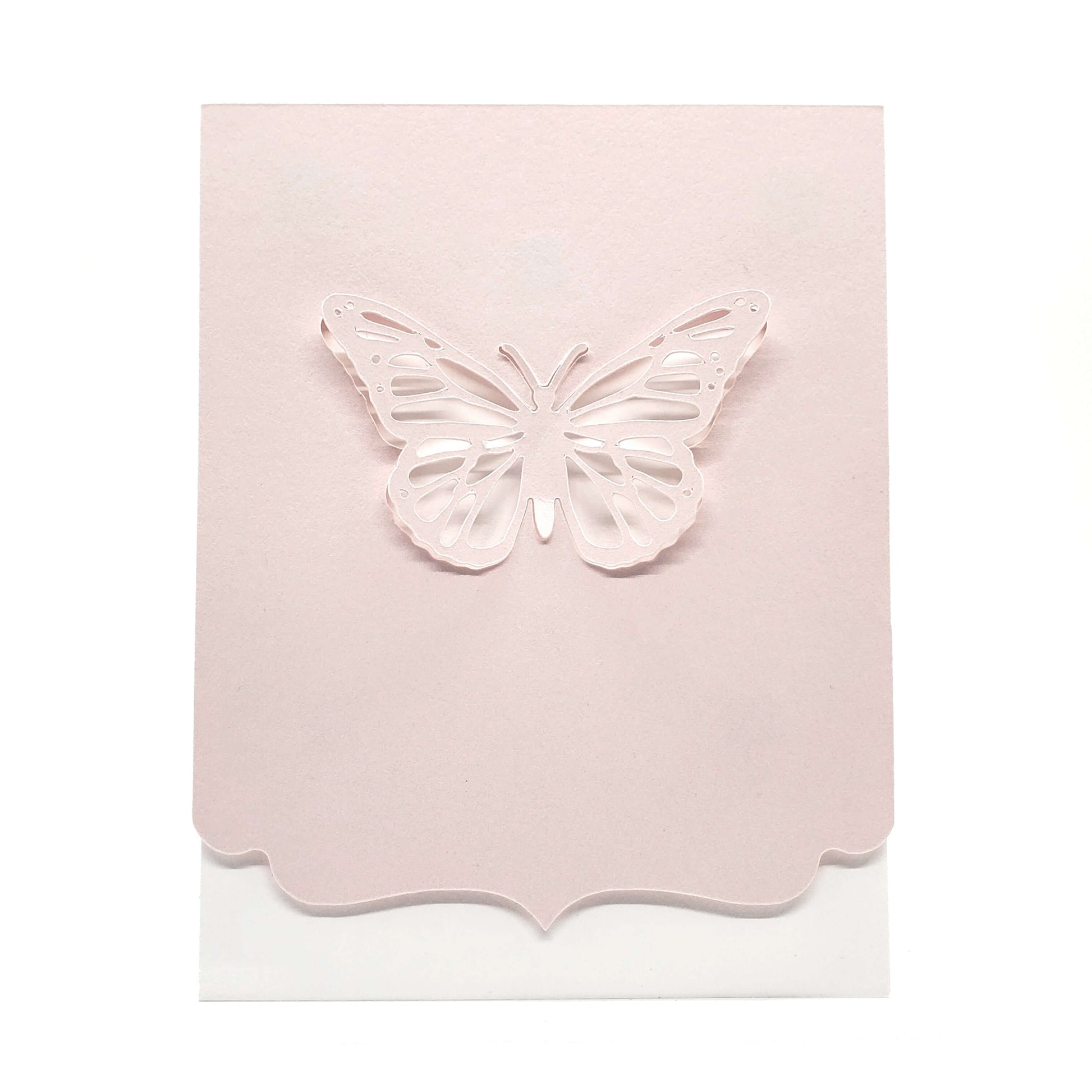 Die cut butterfly from pink cardstock with a decorative edge on a white card.