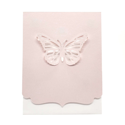 Die cut butterfly from pink cardstock with a decorative edge on a white card.