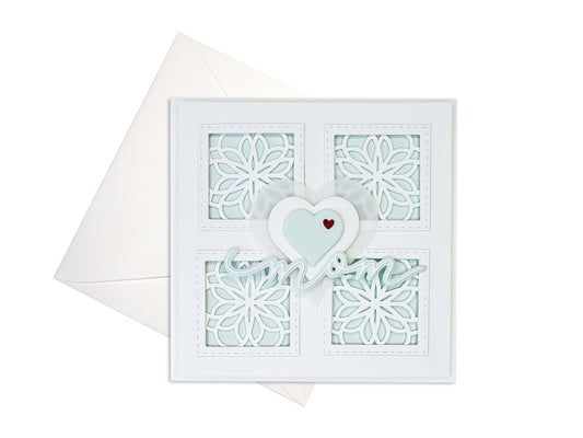 Mother's Day card with 4 squares with die cut motifs, 3 layered hearts in the center with die cut mom underneath. Light Aqua colors with white