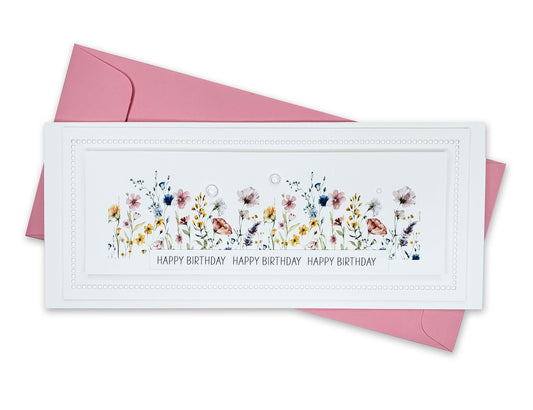 Birthday card with die cut edges and a beautiful row of colorful wildflowers and dew drops