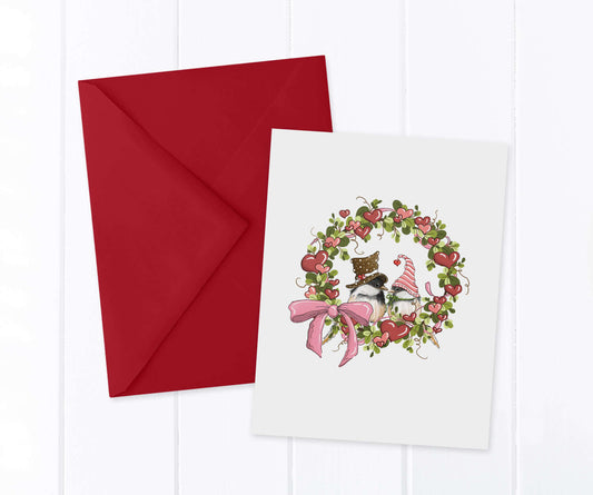2 Chickadees wearing festive Valentine's hats inside a heart and greenery wreath with a pink bow